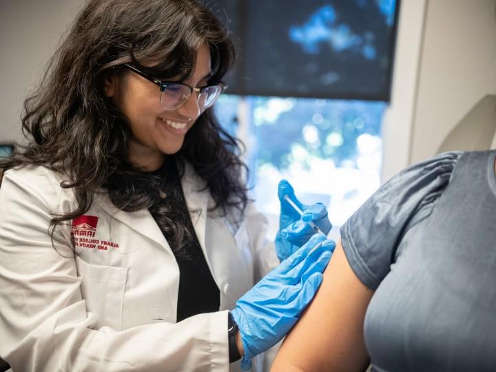 轮岗的学生给病人的手臂注射疫苗