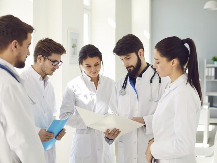 一群穿着实验室大褂的学生聚集在医院观察健康图表